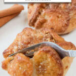 apple blossom on plate being cut with fork and text overlay "frozen apple blossoms in the air fryer".