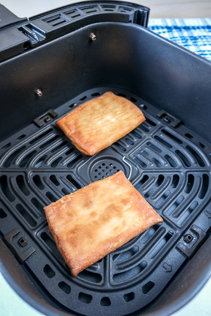 cooked toaster strudels in black air fryer tray on counter top
