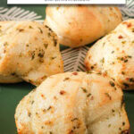 garlic knots on green plate with text overlay "frozen garlic knots in the air fryer".