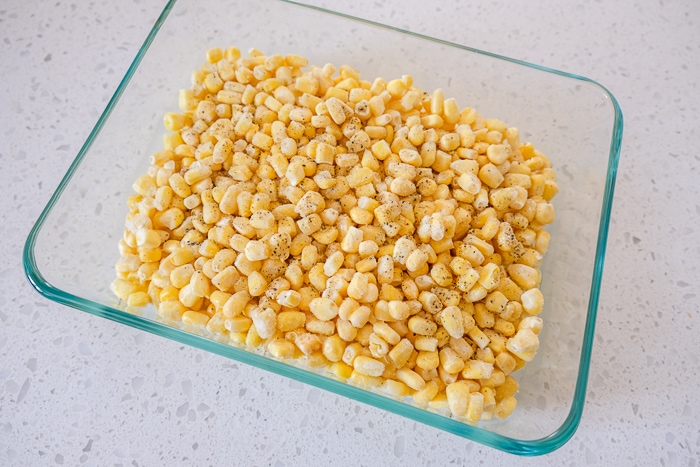 frozen corn in glass dish on white counter top.