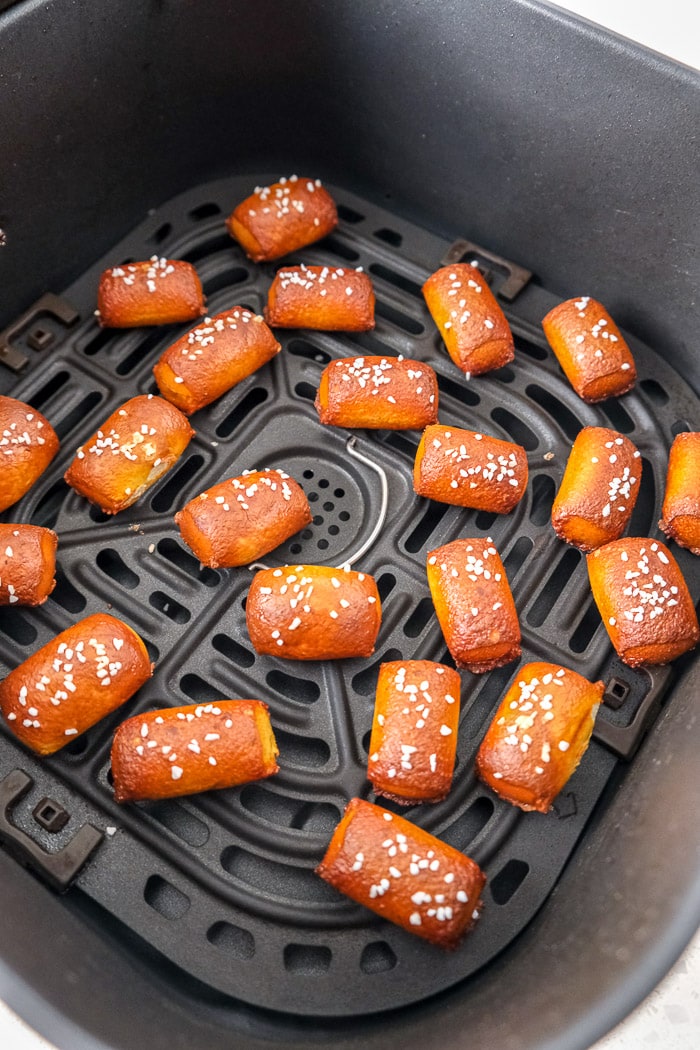 crispy pretzel bites with salt on top in air fryer tray.