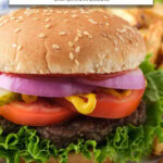 hamburger patty on bun with lettuce, tomatoes, and onions and text overlay "frozen hamburgers in the air fryer".