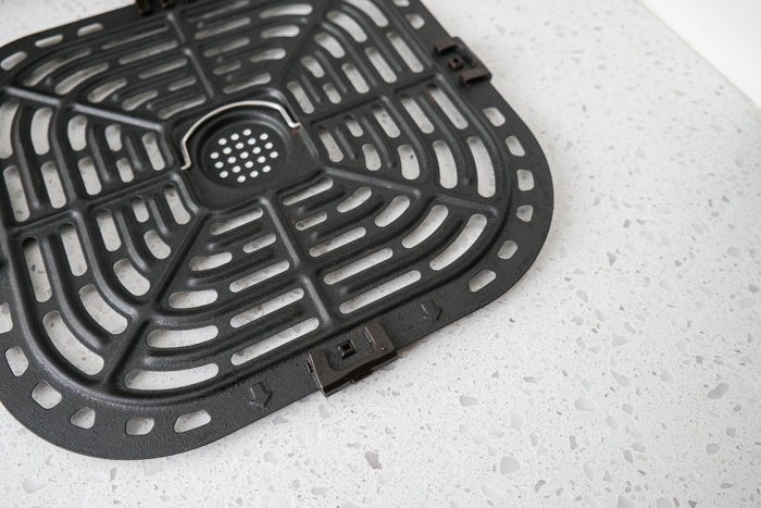 black air fryer tray on white counter.