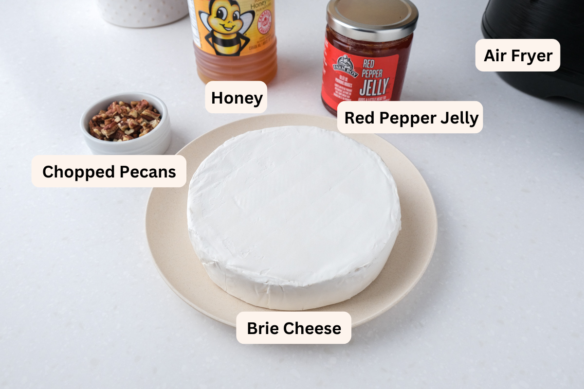ingredients to make baked brie labelled on white counter.