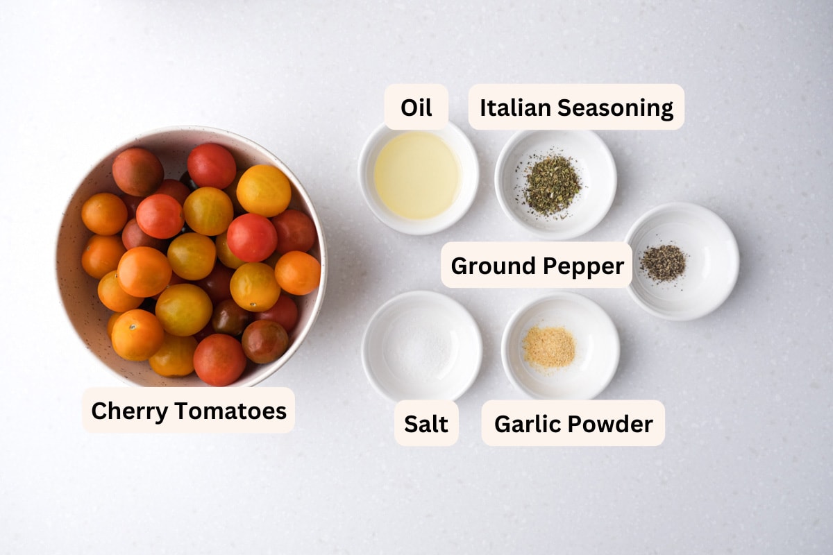 ingredients to make cherry tomatoes in the air fryer with spices in bowls on counter with labels.
