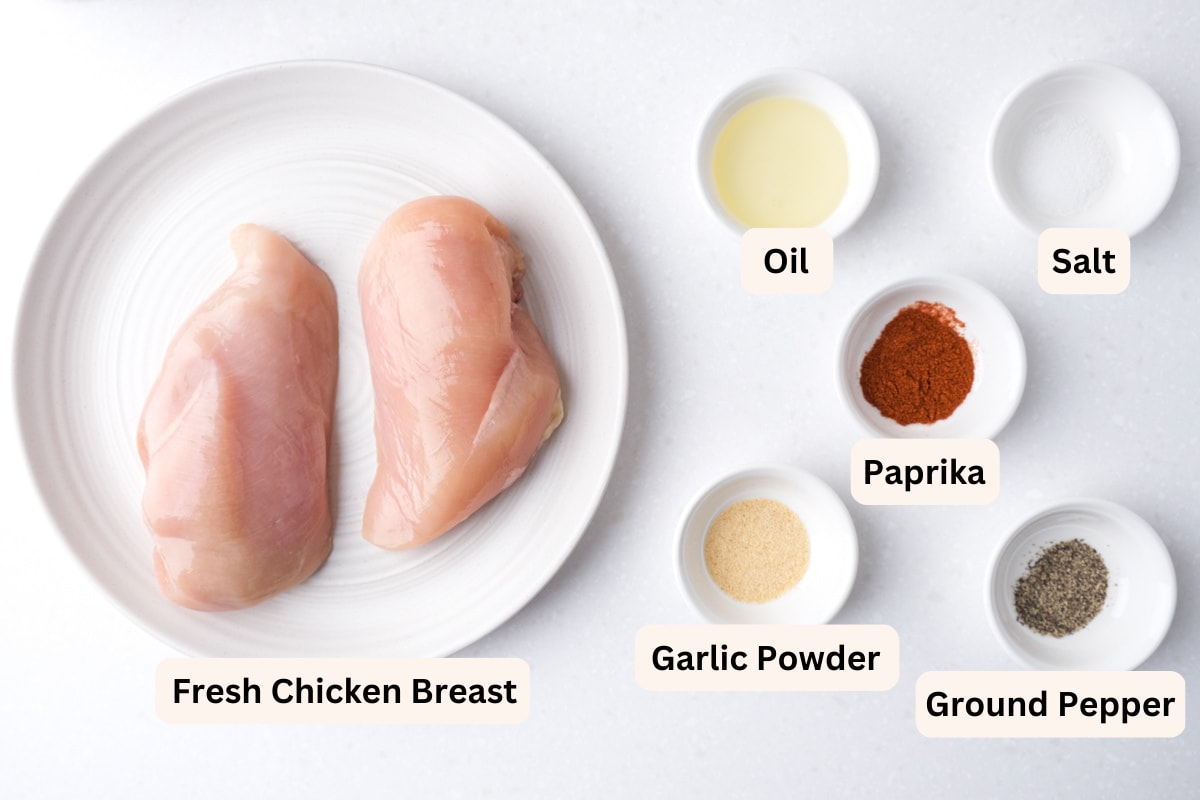ingredients to make air fryer chicken breast on white counter with labels.