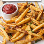 cooked parsnip fries on plate with ketchup and text overlay "parsnip fries in the air fryer".