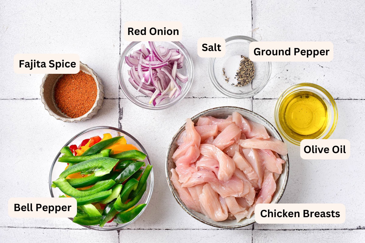 ingredients to make chicken fajitas in bowls on the counter with labels.
