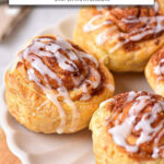 cooked cinnamon buns on white plate with text overlay 