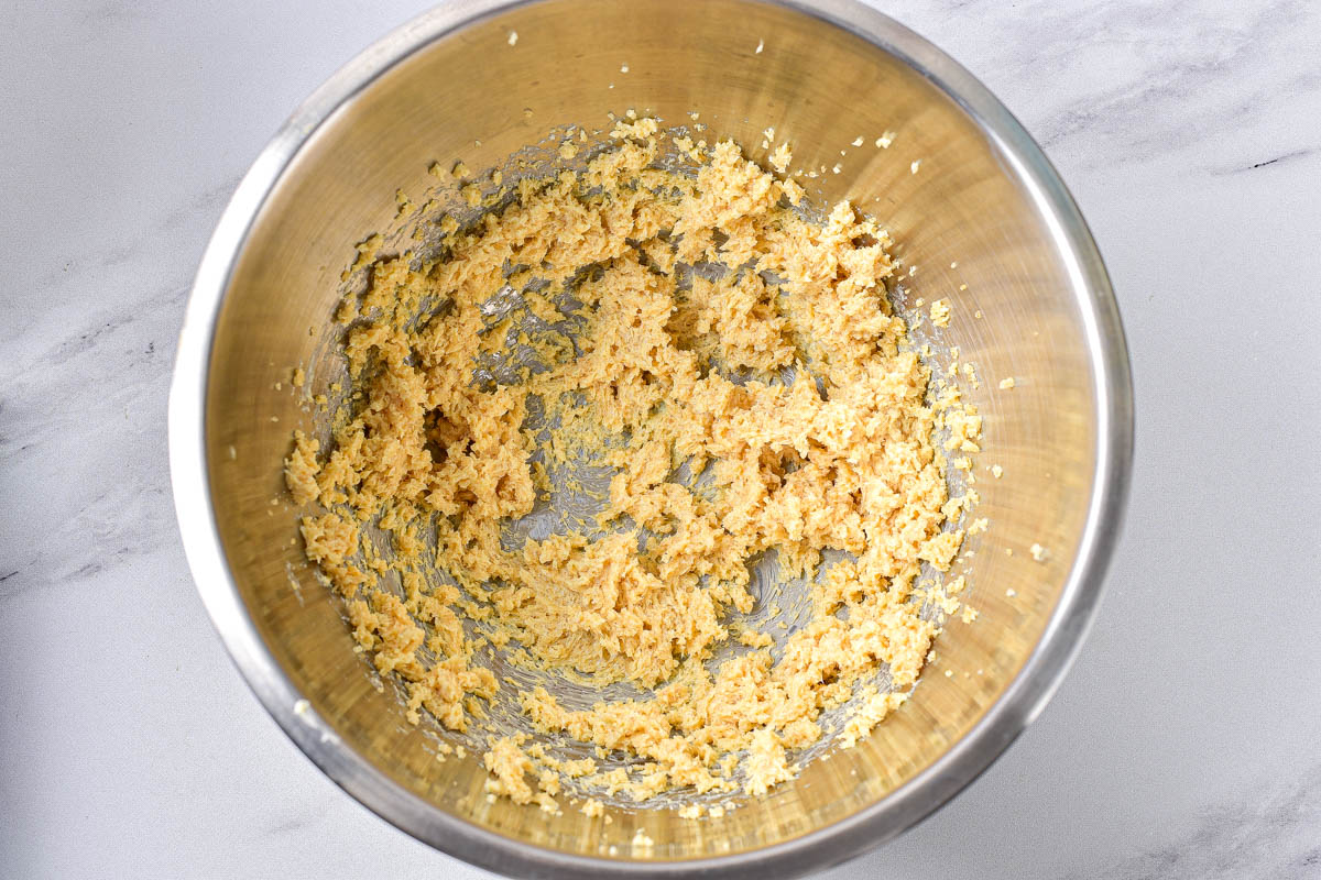 cookie dough batter in silver mixing bowl on counter.