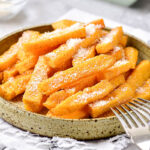 deep plate of crispy polenta fries with two silver forks on edge.