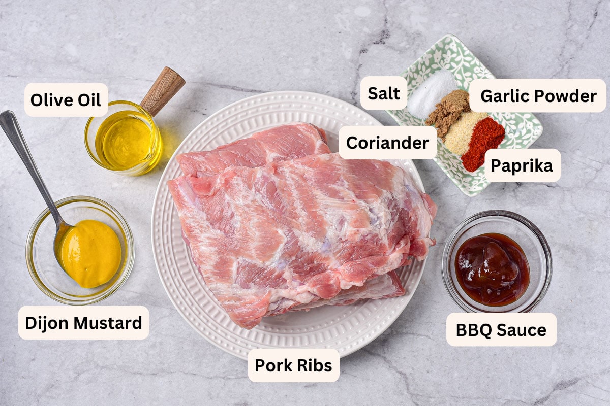 ingredients to make air fryer ribs on counter in bowls with labels.