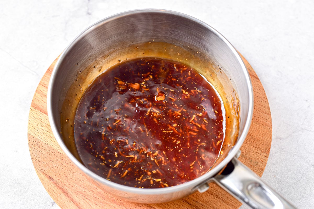 thickened teriyaki sauce on wooden board in sauce pan.
