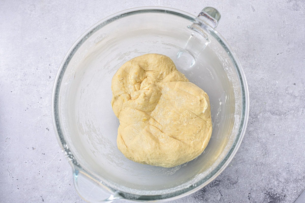 ball of raw dough in glass bowl on counter.
