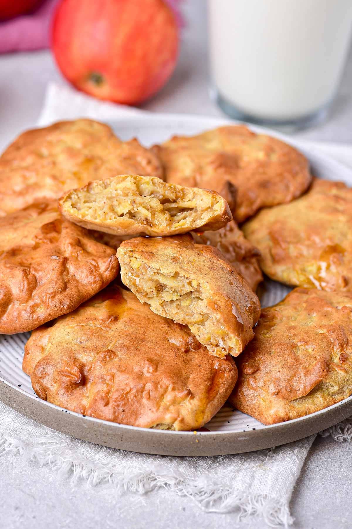 air fried apple fritters on plate with glass of milk and apple behind.