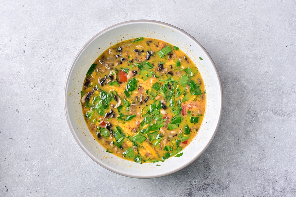 egg and vegetable mixture in white bowl sitting on counter.