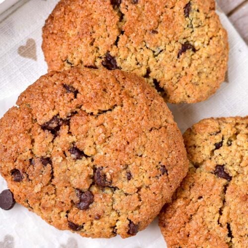 oatmeal chocolate cookies on white parchment paper tray seen from above.