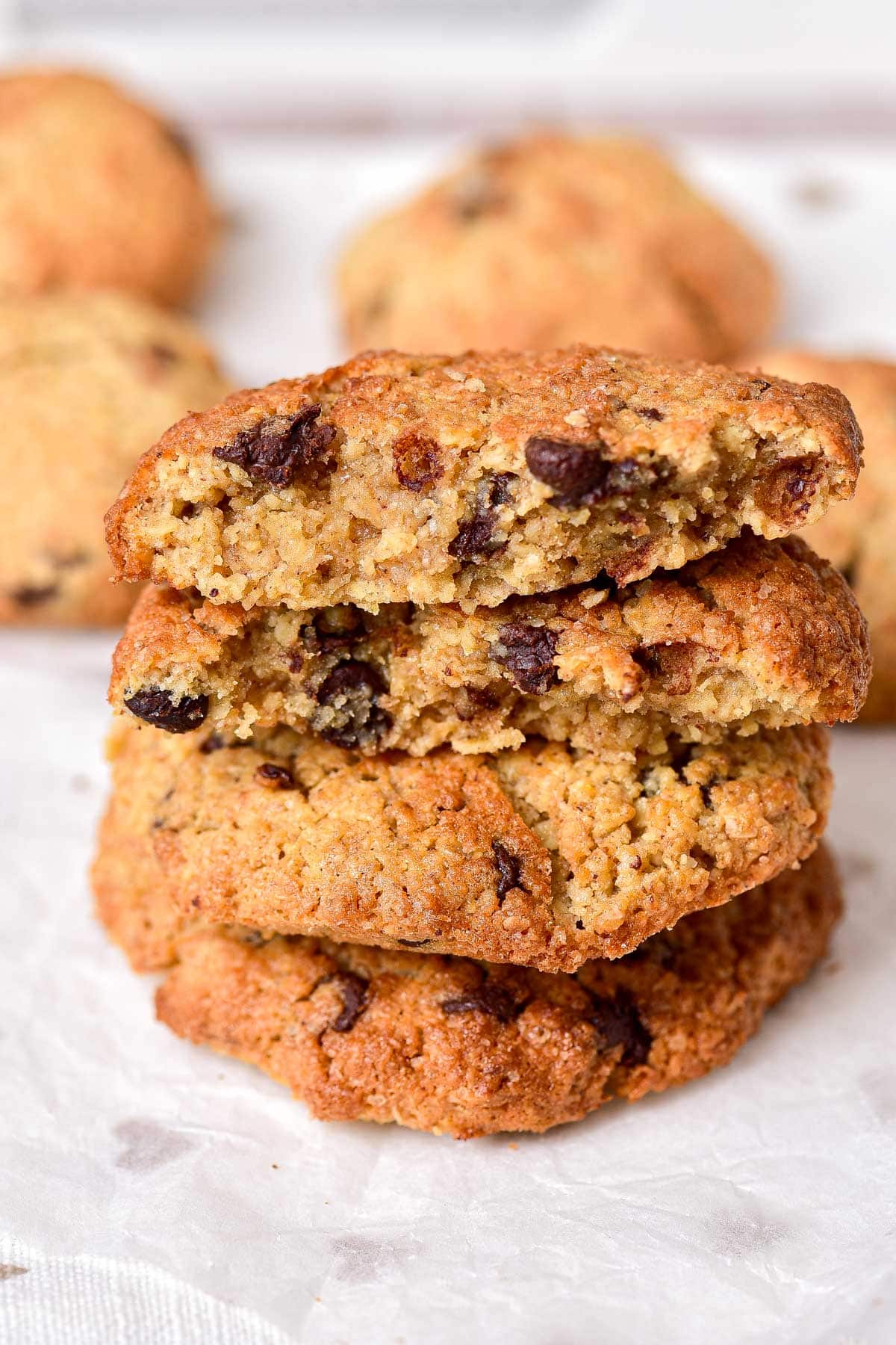 crispy oatmeal cookies in a stack on parchment paper.