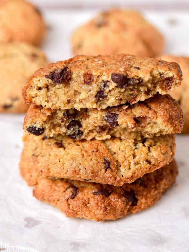 crispy oatmeal cookies in a stack on parchment paper.