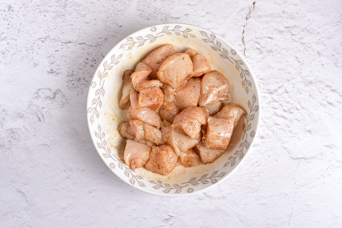 pieces of raw chicken in bowl on counter top.