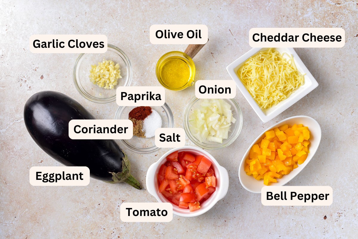 ingredients to make stuffed eggplants in bowls on counter with labels.