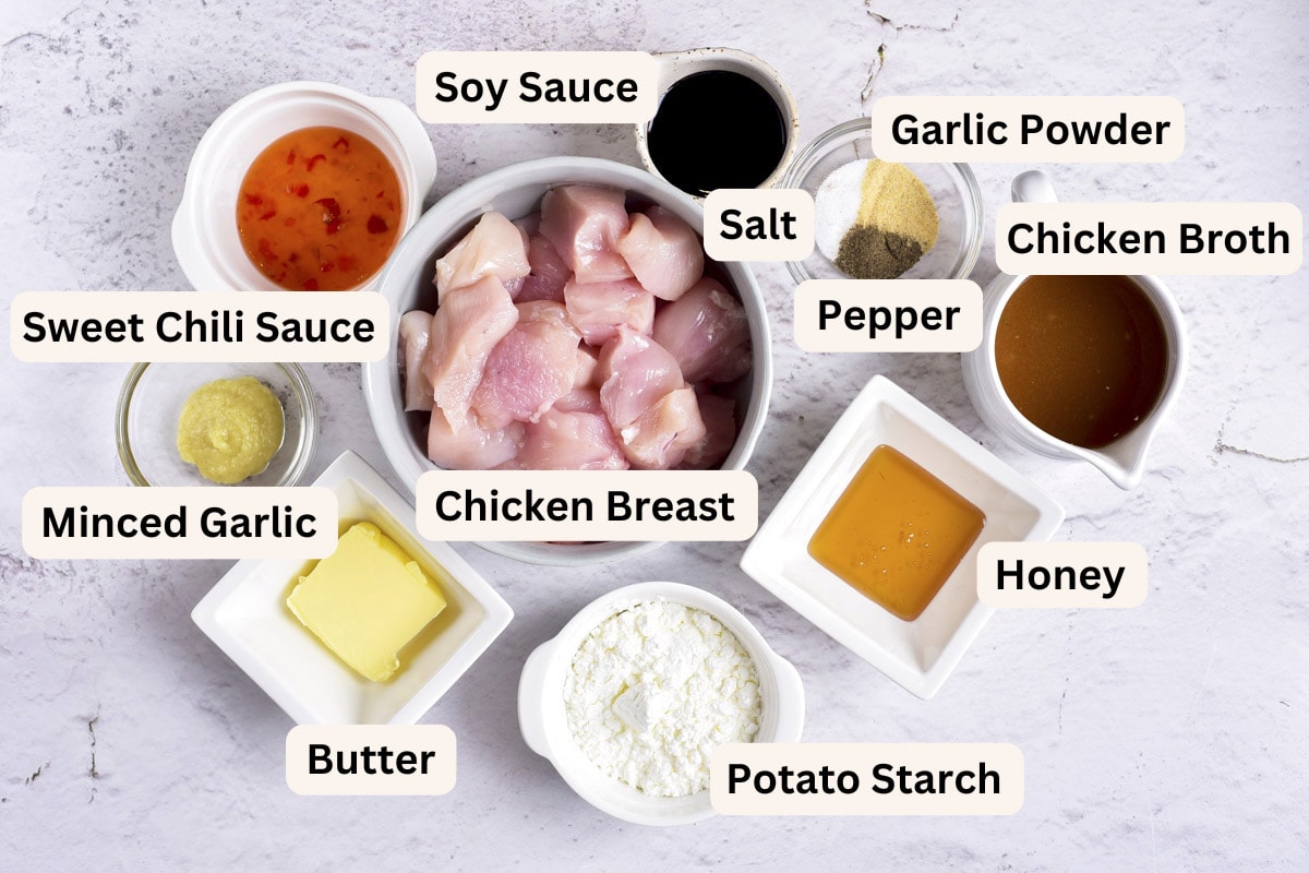 ingredients to make honey garlic chicken on counter in bowls with labels.