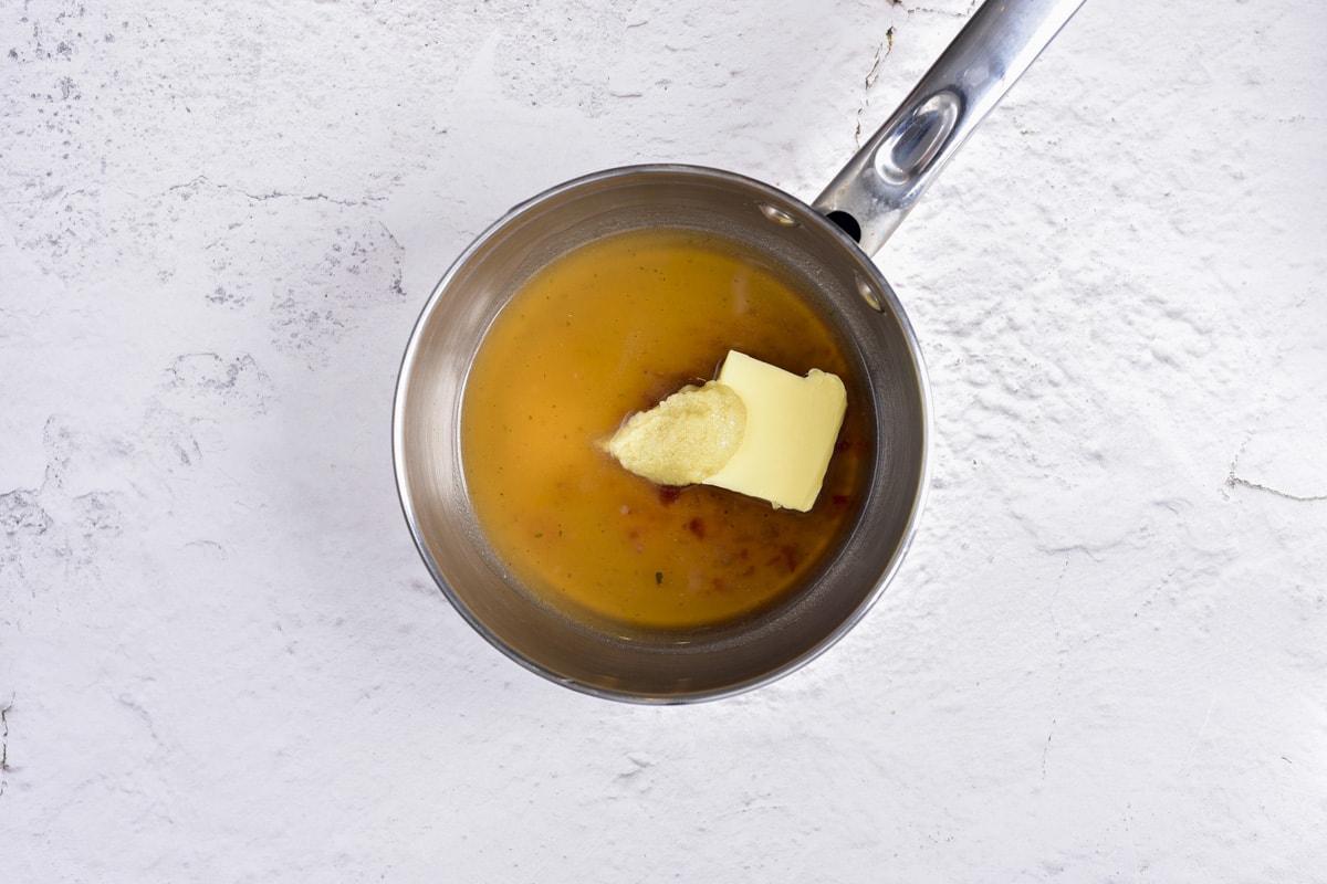 silver pot on counter top with butter melting inside.