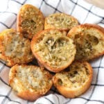 crispy pieces of garlic bread in basket with white cloth.