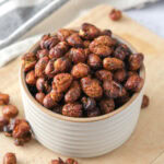 small bowl of crispy fava beans on wooden board.