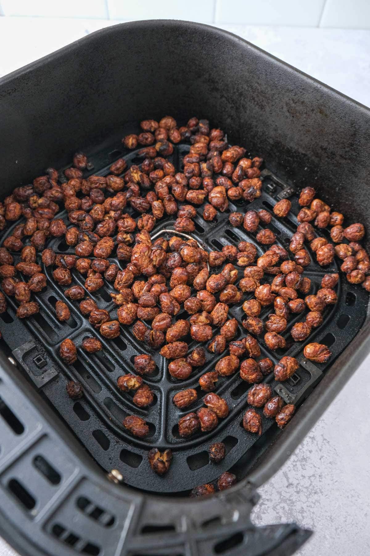 crispy air fryer fava beans in air fryer basket on counter.
