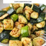 cooked pieces of zucchini in bowl with text overlay "air fryer zucchini".