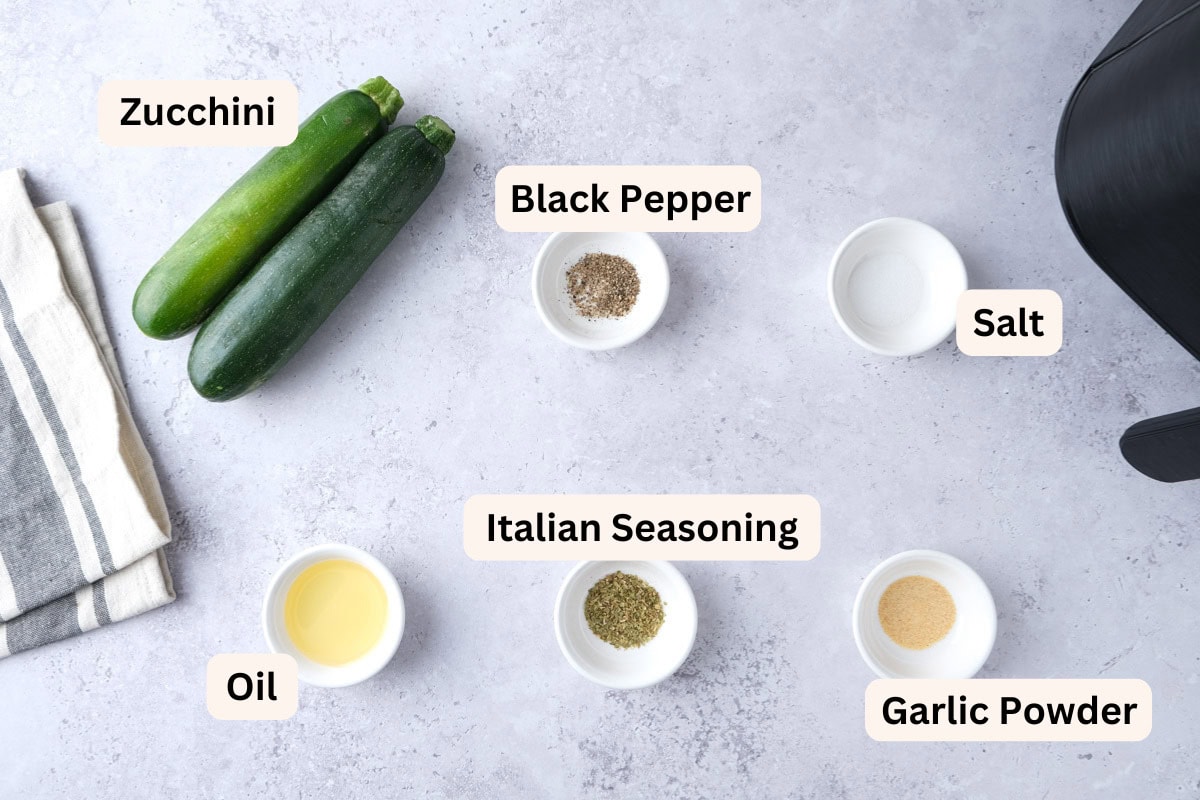 ingredients to make air fryer zucchini on counter in bowls.