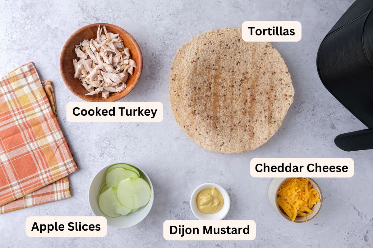 ingredients for turkey wraps on counter in bowls with labels.