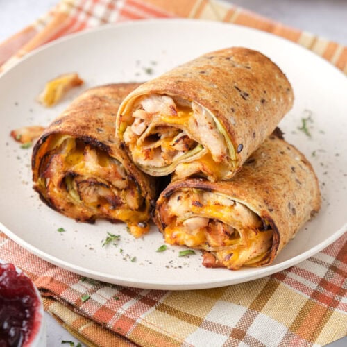 turkey apple rollups on plate with festive cloth underneath.