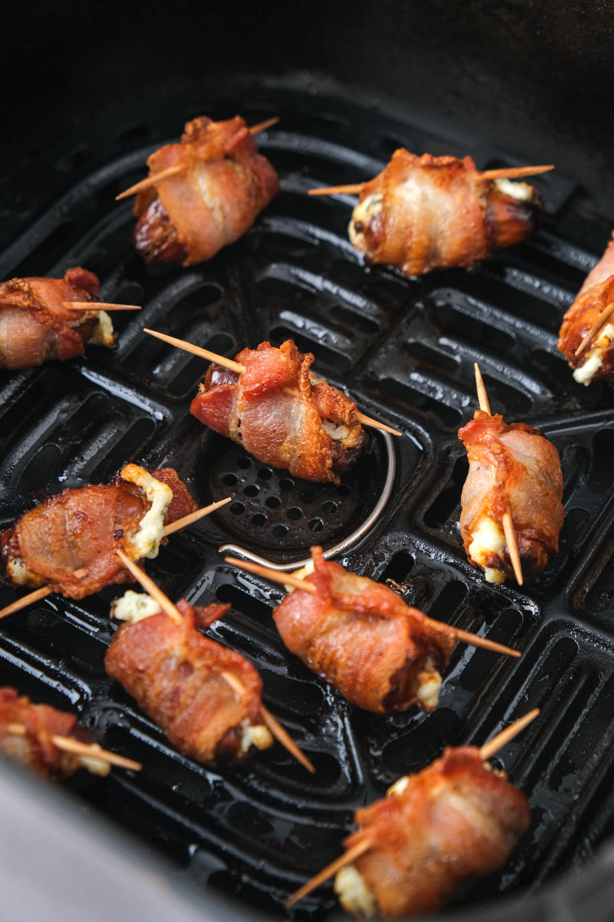 crispy bacon wrapped dates in air fryer basket.