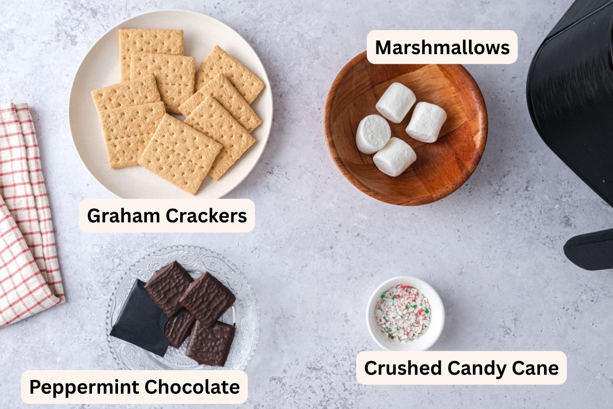 ingredients to make smores on plates on counter with labels.