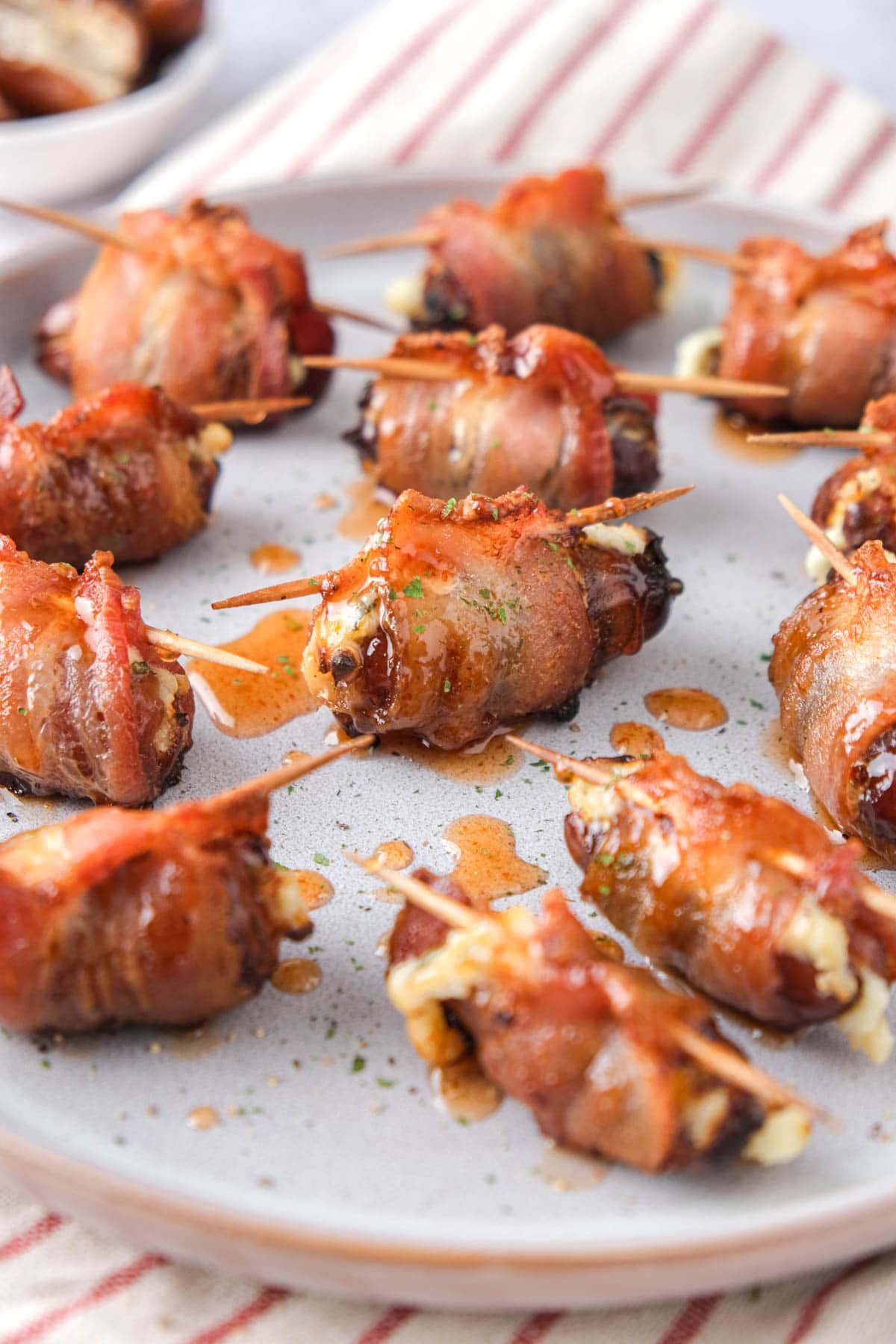 bacon wrapped dates on a plate covered in honey.