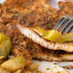cooked pork chops and apples on white plate with fork and text overlay "air fryer pork chops and apples".