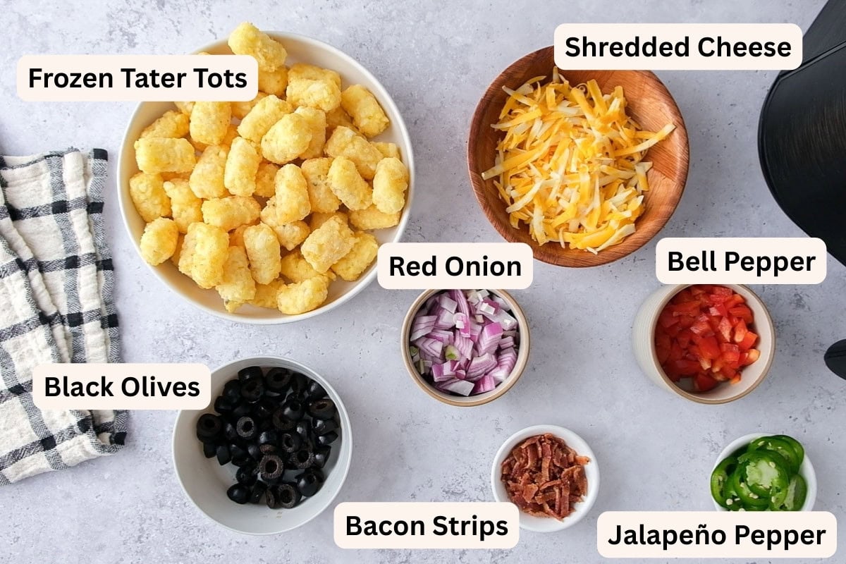 ingredients to make loaded tater tots on counter in bowls with labels.