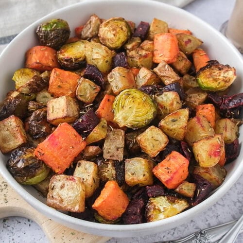 white bowl of roasted vegetables on wooden board.