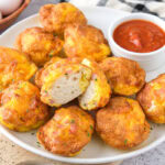 egg and biscuit bites on plate with ketchup behind.
