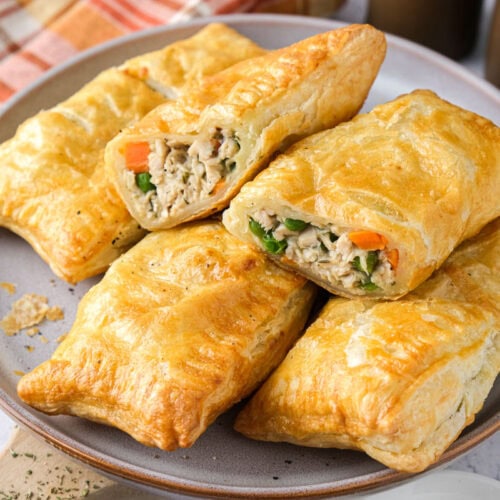 chicken hand pies stacked on a plate.