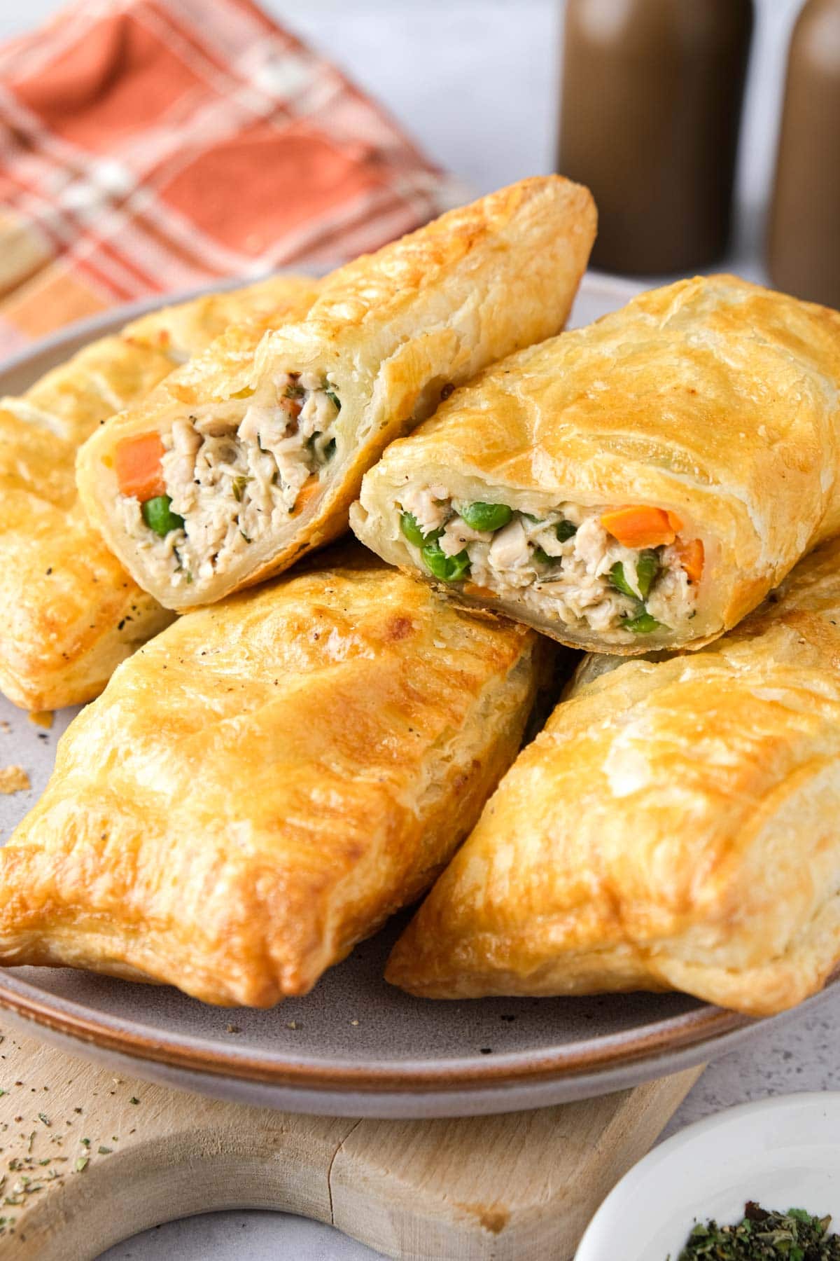 chicken hand pies in puff pastry in a pile on a plate.