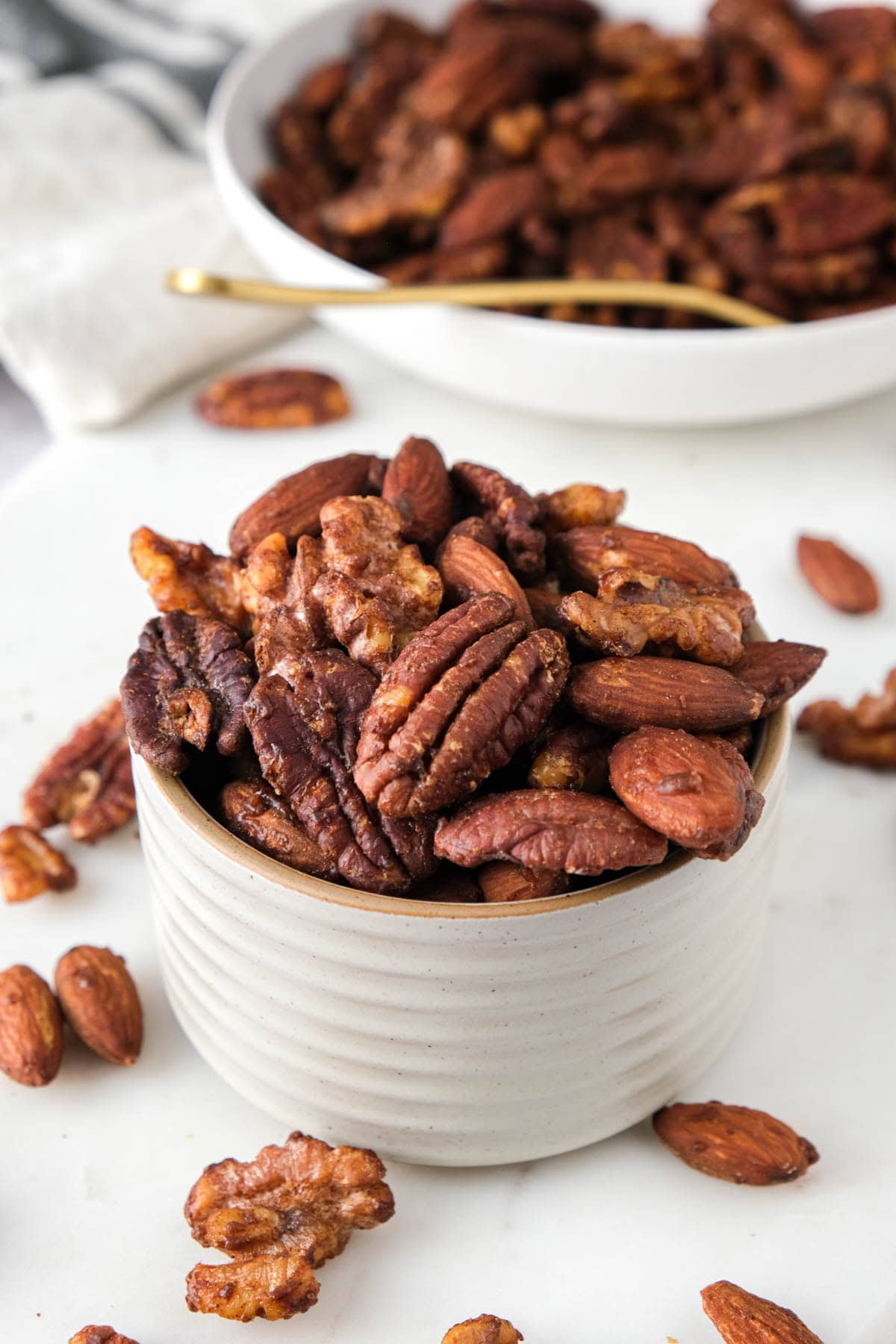 roasted mixed nuts in ramekin on counter with more behind.
