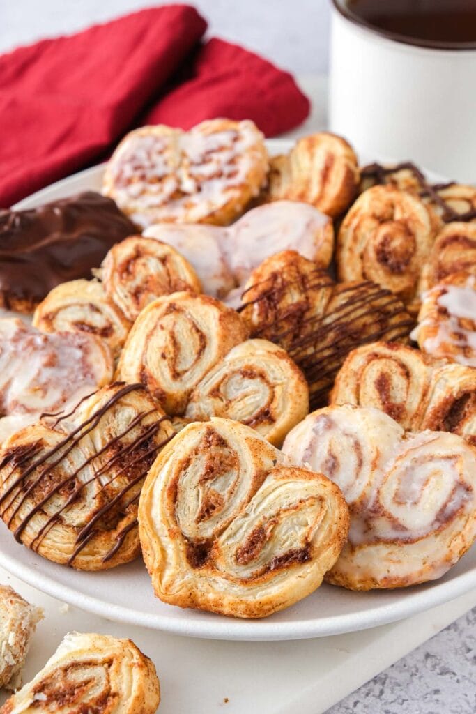 puff pastry hearts on plate with coffee behind.