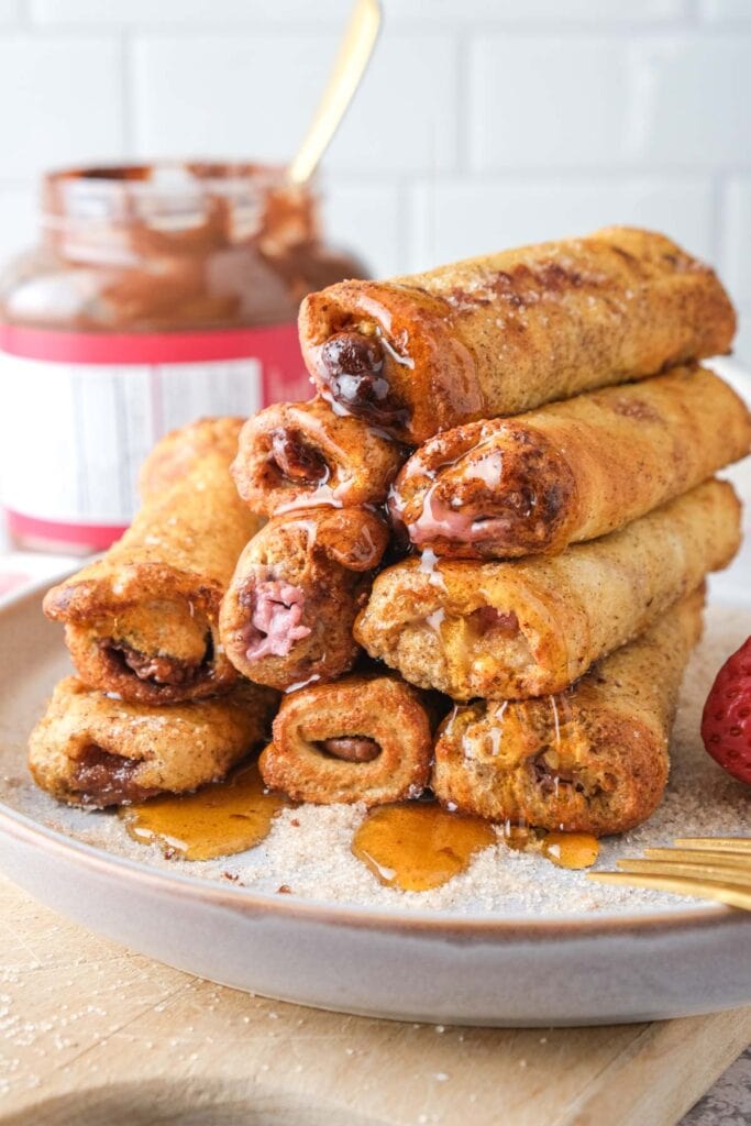 air fryer french toast roll ups on plate with syrup.
