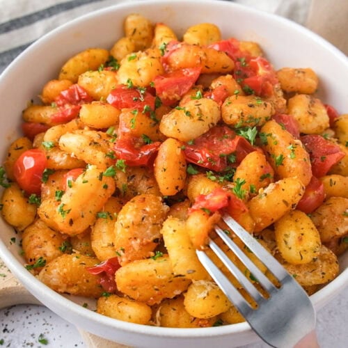 bowl of cherry tomato gnocchi with fork piercing some.