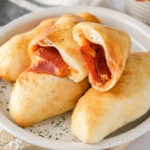mini calzones cut open stacked on plate with others.