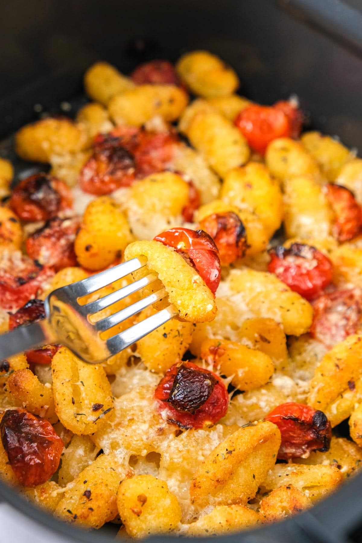 silver fork in cherry tomato gnocchi in air fryer.