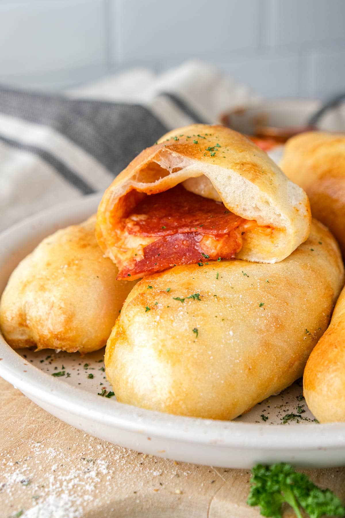 mini calzone cut in half with cheese and pepperoni spilling out.